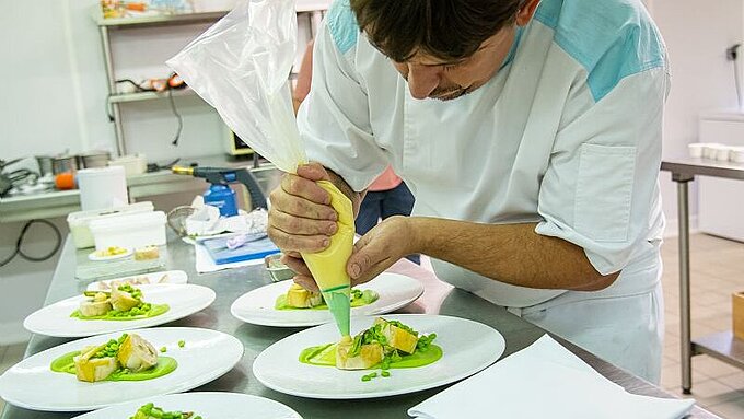 Un restaurateur en train de réaliser son plat